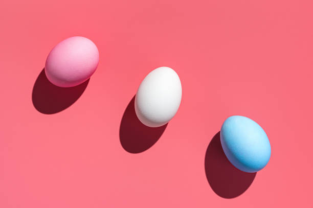 istock Three Easter eggs of different colors on a pink background 1369152967