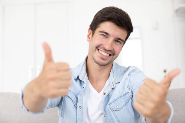 istock Front view on joyful man showing thumbs up gesture to laptop camera starting video communication with friend or partner using video call chat 1369156218