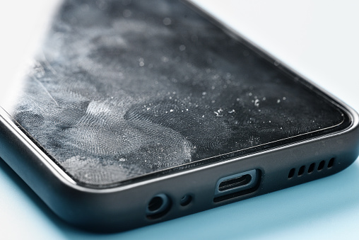 Smartphone screen surface with fingerprints and pollution close up