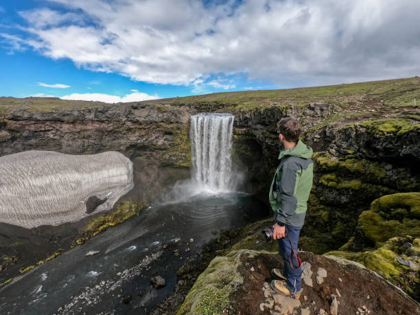 istock One man on a hiking in Iceland and contemplating waterfall 1369162993