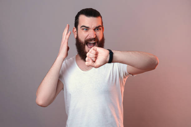 istock Bearded man is stressed because of the time while watching his watch. 1369164527