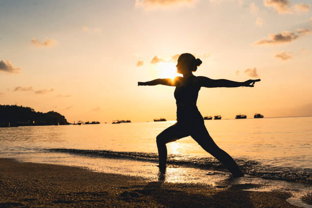 istock Woman doing yoga at the beach. 1369166265