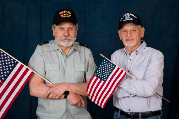 istock Retired Veterans cradling American Flags looking at camera 1369166282