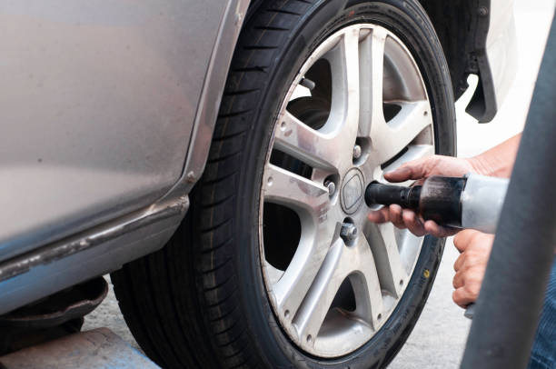 istock Unidentifield automobile engineer use wind block and hand change new car tire instead the bald tyre. 1369167462