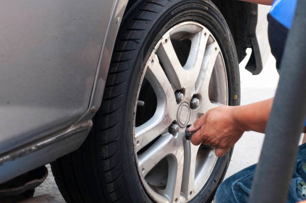 istock Unidentifield automobile engineer use wind block and hand change new car tire instead the bald tyre. 1369167500