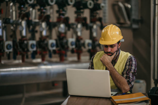 energy plant worker Hardworking energy plant worker in working suit and with protective helmet oil pump petroleum equipment development stock pictures, royalty-free photos & images