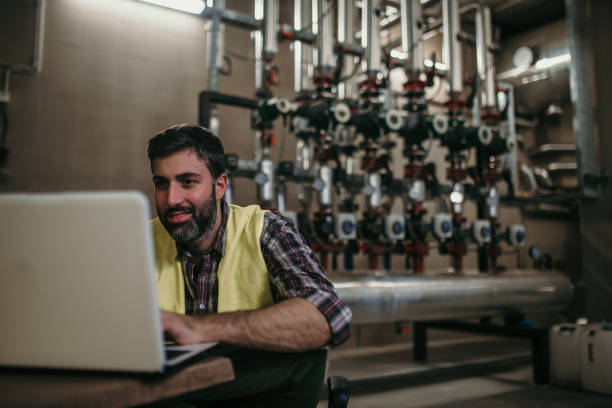 energy plant worker Hardworking energy plant worker in working suit and with protective helmet oil pump petroleum equipment development stock pictures, royalty-free photos & images