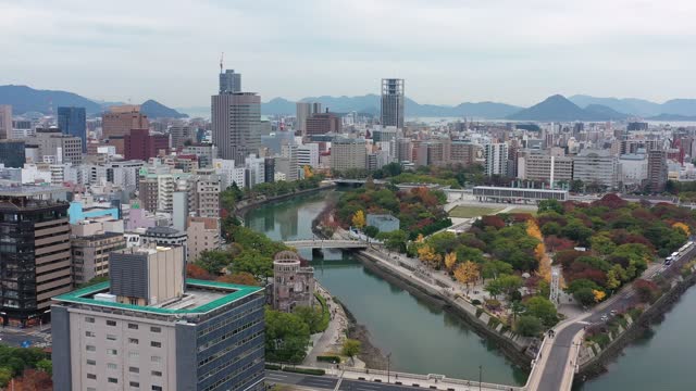 Aerial view of Atomic Bomb Dome (Hiroshima Peace Memorial) and Peace Memorial Park in city of Hiroshima, autumn scenery with colorful trees - landscape panorama of Japan from above, Asia