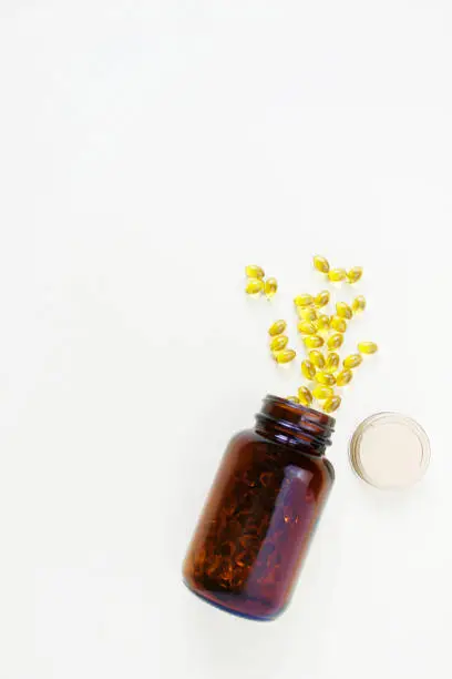 Photo of Yellow omega 3 capsule pattern. Different gold pills. Medical banner. Cosmetology wallpaper. Medicine vitamin.