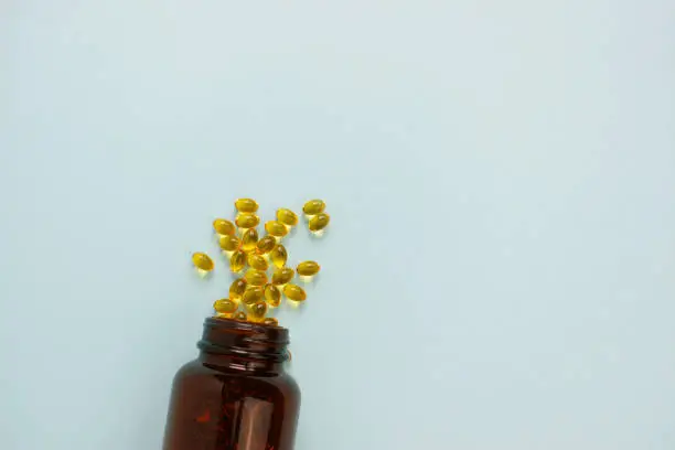 Photo of Yellow omega 3 capsule pattern. Different gold pills. Medical horizontal banner. Cosmetology wallpaper. Medicine vitamin.