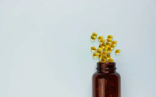 Photo of Yellow omega 3 capsule pattern. Different gold pills. Medical horizontal banner. Cosmetology wallpaper. Medicine vitamin.