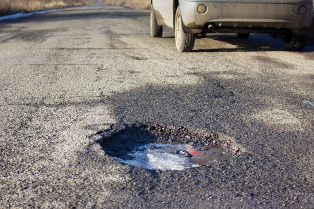istock Pit on the asphalt. The car in the background. 1369175167