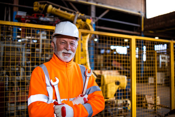 istock Professional industrial serviceman standing by automatic robot arm machine in production factory. 1369175293
