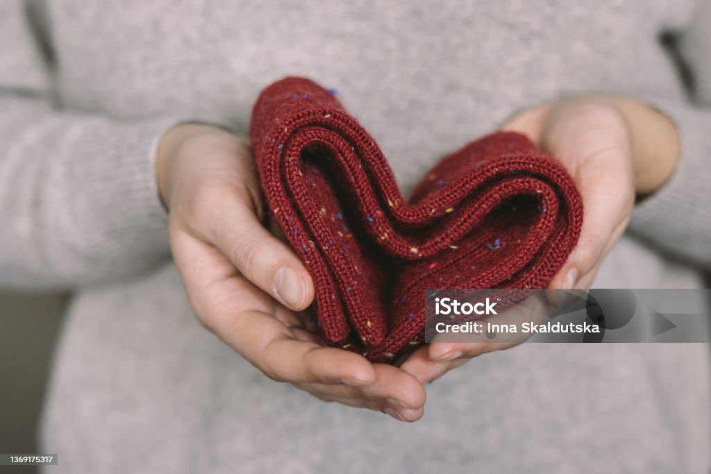 Woman with knitted socks in her hands. Concept for handmade and hygge slow life. Sock Stock Photo
