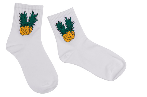 pair of white socks with pineapple pattern lying on white background, isolate