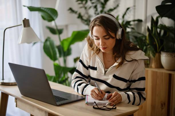 istock Young woman using laptop at home to work or study 1369175568