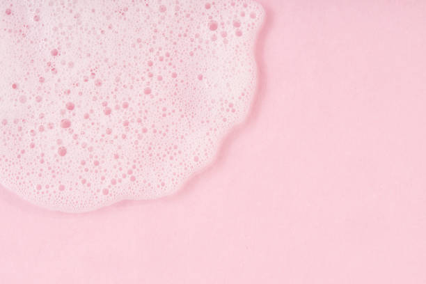 White cleanser foam drop on pink background. stock photo