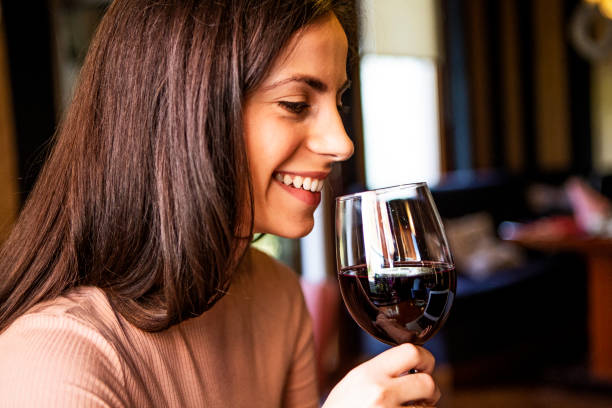 istock Young smiling woman drinking wine 1369175632
