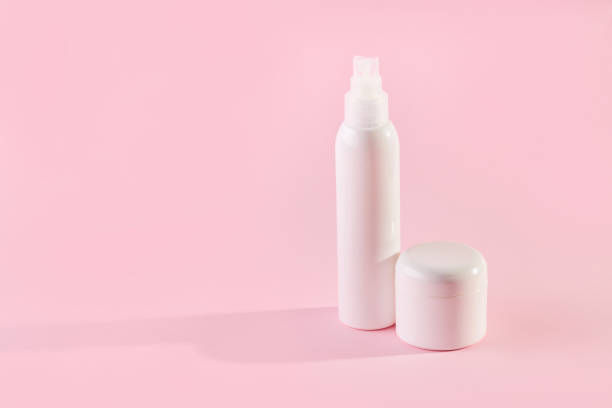 istock Two white plastic jars with cosmetics on a pink background 1369175677