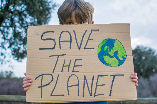 6 Year Old Boy Holding A Cardboard Sign That Says SAVE THE PLANET.