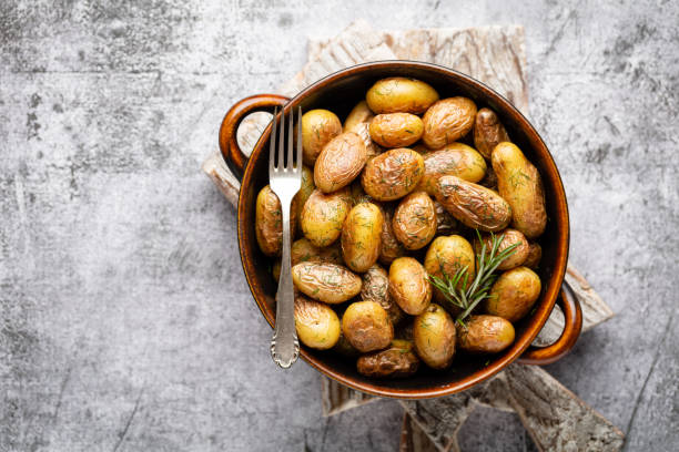 istock Pan filled with roasted potatoes shot on rustic wooden table. 1369178627
