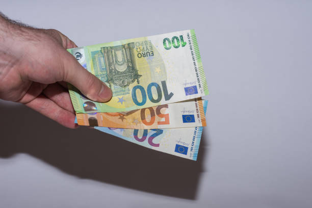 istock three euro bank notes held in one hand to the bottom with gray 1369181045
