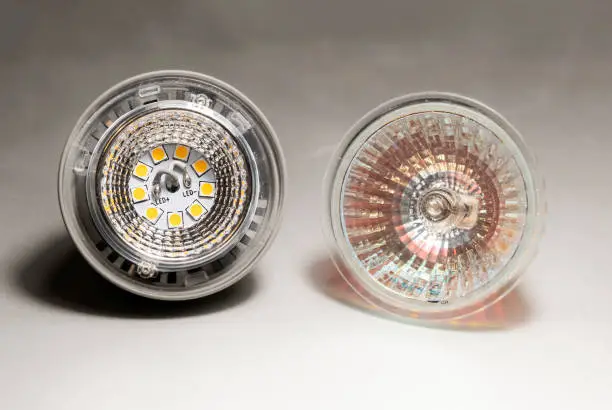 Photo of two halogen spotlight on a blurred surface, selective focus, led technology versus conventional halogen bulb, 5W versus 50W cosume, hight energy efficiency