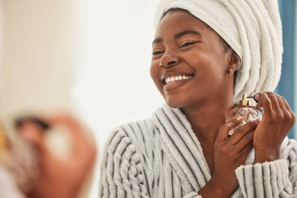 tiro de uma jovem mulher parecendo alegre enquanto usa perfume - perfume - fotografias e filmes do acervo