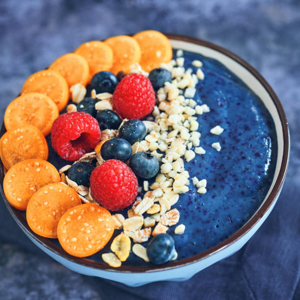 Blueberry Spirulina Smoothie in Bowl with Physalis, Berries and Superfoods on Top