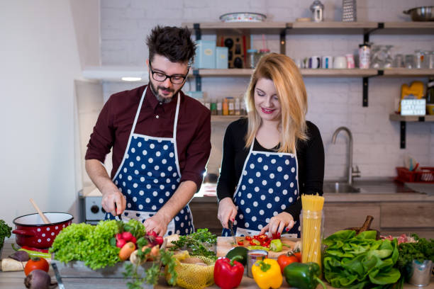 istock Happy couple cooking dinner together 1369184524