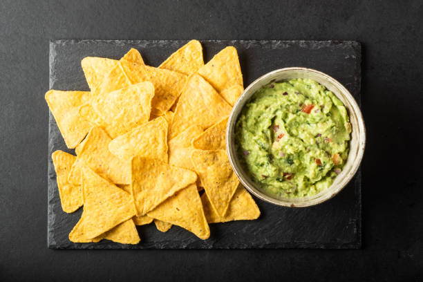 istock Mexican nachos chips and guacomole sauce 1369185021