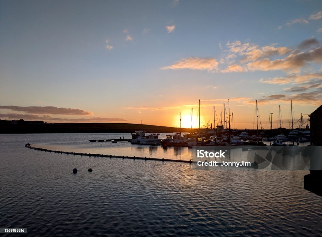 Orkney Stromness Marina sunrise Sunrise early on a winter morning looking at Various boats in the marina Stromness Orkney islands Scotland Bay of Water Stock Photo