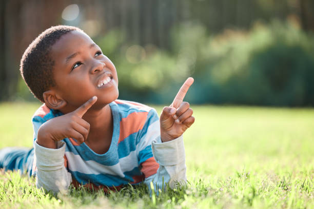 istock Shot of a young boy lying on the grass outside 1369187532