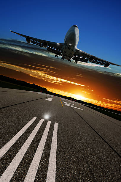 istock XL jumbo jet airplane landing at sunset 136918789