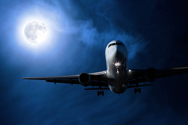 istock jet airplane landing at night 136918796