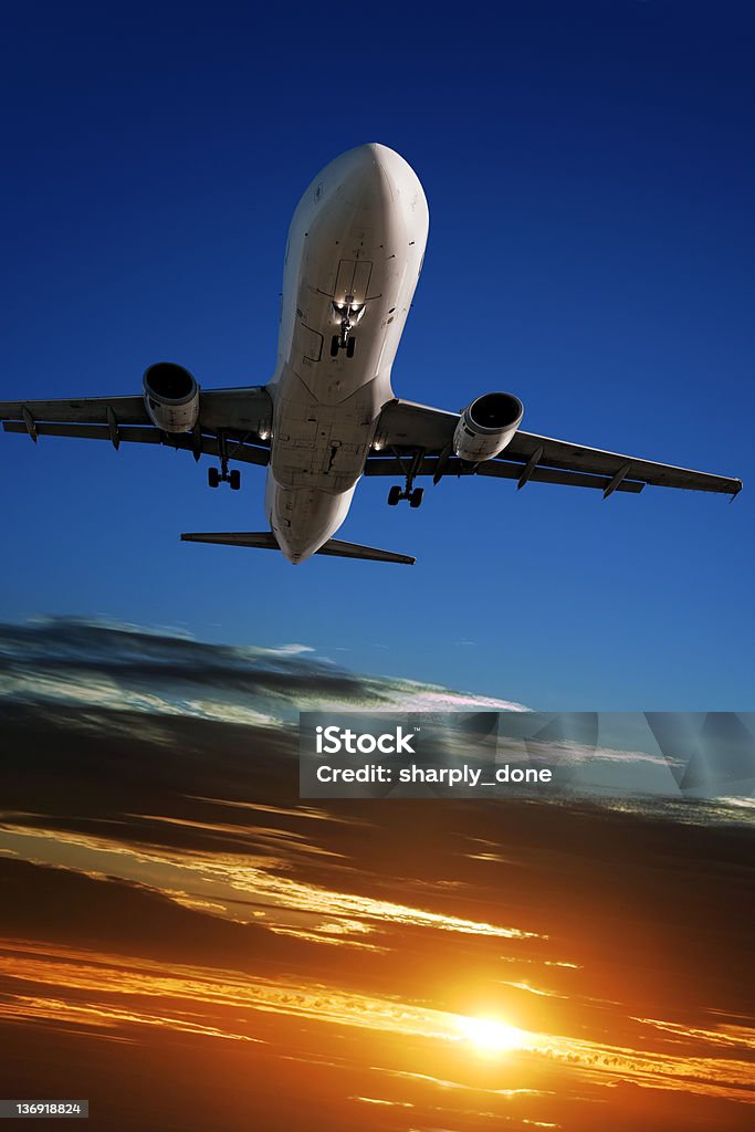 XL jet airplane landing at sunset jet airplane landing at sunset, vertical frame (XL) Sunset Stock Photo