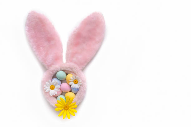 Easter Eggs hand painted inside bunny ears pink fur, spring daisy flowers isolated on white background