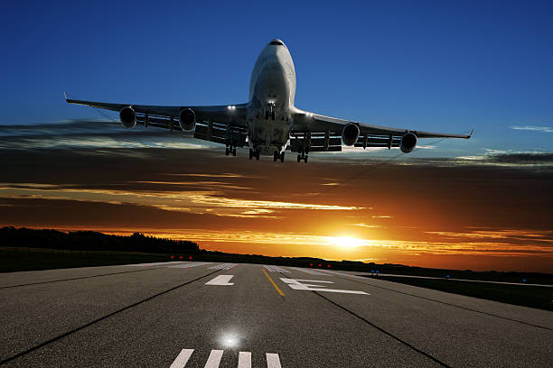 istock XL jumbo jet airplane landing at sunset 136918833