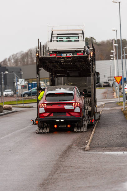 新しい赤いフォードマスタングマッハエ電気自動車は、車の輸送からアンロードされています. - car hybrid vehicle isolated new ストックフォトと画像