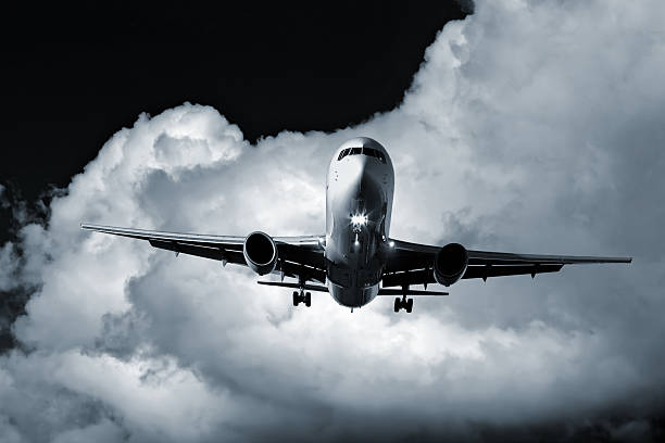 jet airplane landing at night with storm cloud