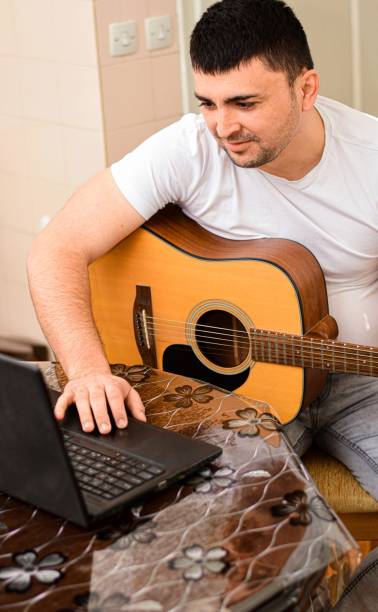 istock Mid age man taking an online course for guitar 1369191331