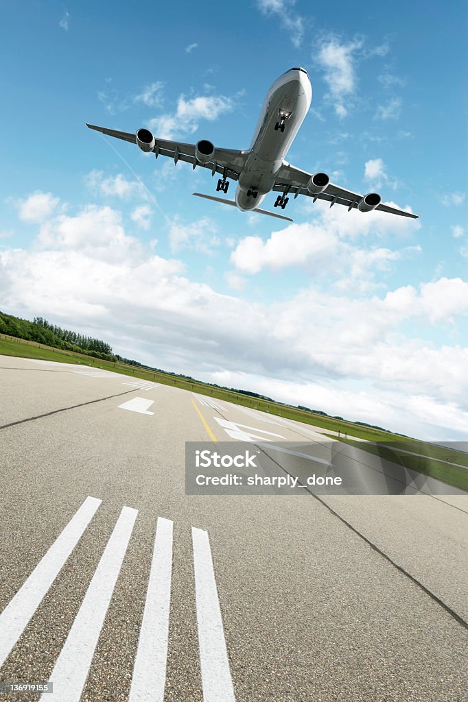 XXL jet airplane landing jet airplane landing on runway with bright sky, vertical frame (XXL) Airport Runway Stock Photo