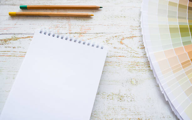 istock Paint samples interior design natural Colors. Wooden background, notebook, pencils, copy space 1369191752