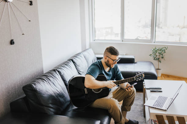 istock Acoustic guitar teaching through a video callteaching, 1369192102