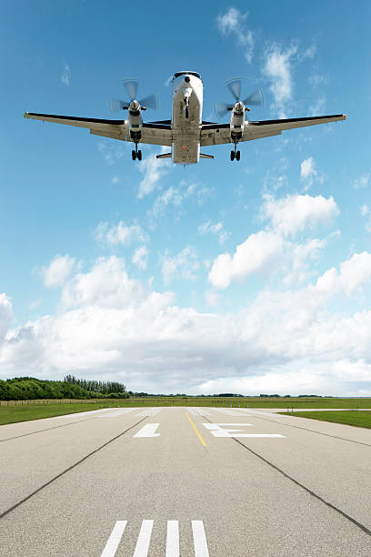 XXL propeller airplane landing twin propeller airplane landing on runway with bright sky, vertical frame (XXL) airplane commercial airplane propeller airplane aerospace industry stock pictures, royalty-free photos & images