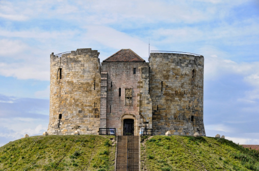 Cliffords tower in york which sits on top of a hill looking out over the city.