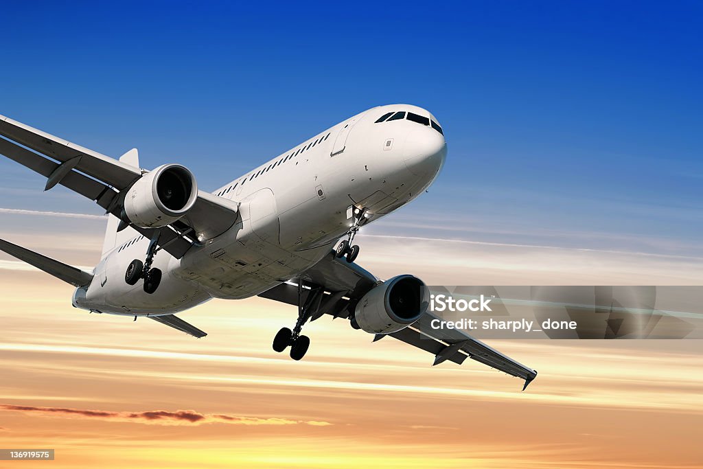 jet airplane landing at sunset jet airplane in close-up landing at sunset Airplane Stock Photo