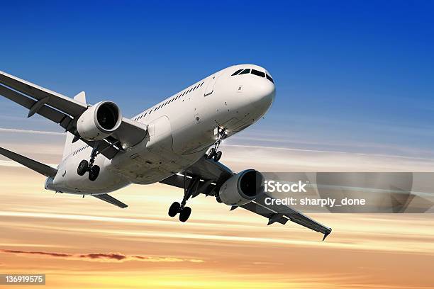 Jet Airplane Landing At Sunset Stock Photo - Download Image Now - Airplane, Large, Commercial Airplane