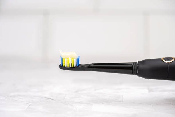 Modern electric toothbrush with toothpaste closeup. stock photo