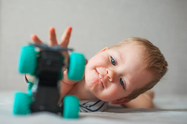 Funny toddler boy playing with toy car